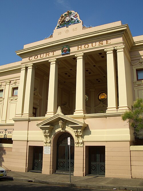 Newtown Court House on Australia Street, a pink stucco Victorian facade with paired columns and COURT HOUSE lettered across the pediment.