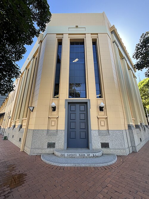 The former Savings Bank of South Australia, a rendered front with tall piers, a granite base and the bank's name cut into the step at the door.
