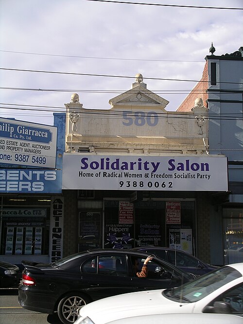 A Sydney Road shopfront with 580 worked into its pediment, an older painted sign under a newer awning.