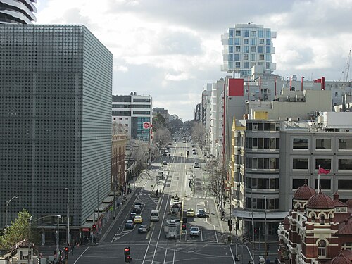 An elevated view north along Swanston Street, tram tracks down the centre of the road, heritage buildings mixed with modern towers.
