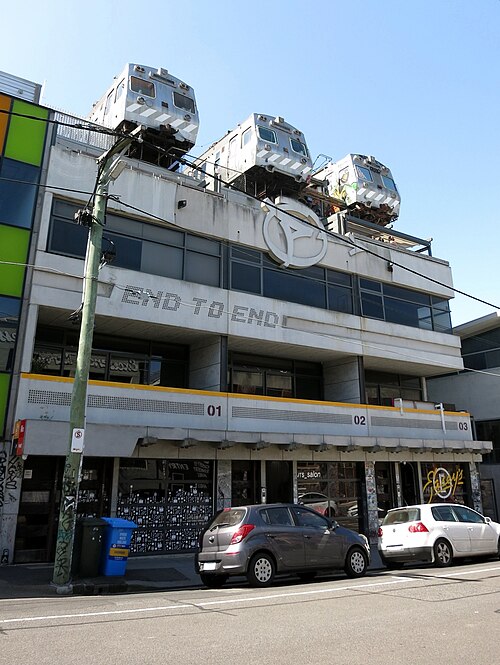 The End to End building, a multi storey commercial block with three retired train carriages mounted on its roof deck.