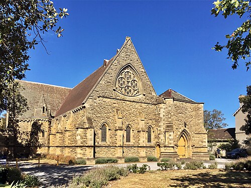Christ Church's stone Gothic Revival facade on Acland Street, a rose window and pointed arch windows above a gravel drive.
