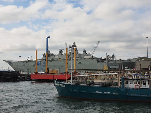 Naval vessels docked at the Williamstown shipyard, with fishing boats moored in the foreground.