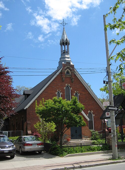 The Church of the Epiphany and St. Mark on Cowan Avenue, red brick with a grey spire and pointed Gothic windows, parked cars along the curb.