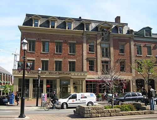 The Edward Leadlay Company warehouse on Front Street, its ground floor now an LCBO liquor store, a construction crane visible over the roofline.