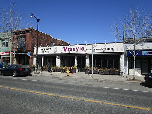 Vesuvio Pizzeria and Spaghetti House, a storefront on Dundas Street West with a purple sign, take out lettering and planters along the sidewalk.