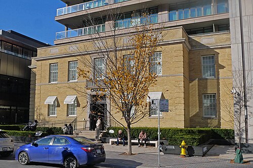 100 Yorkville Avenue, the 1923 hospital building now occupied by Chanel, a glass tower rising behind it.