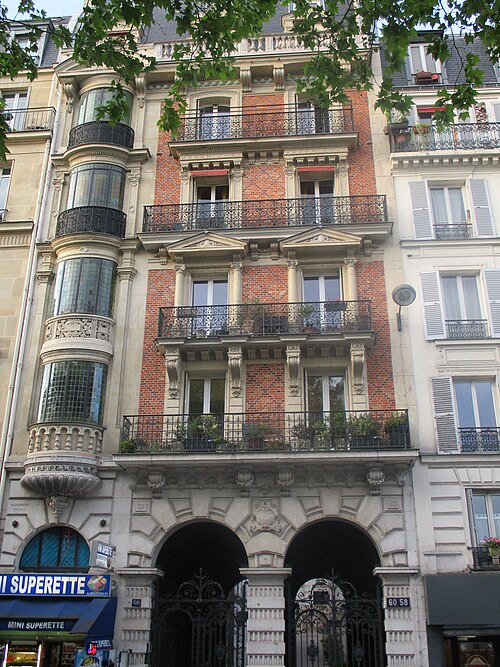 The Villa des Platanes at 58 and 60 boulevard de Clichy, a brick and stone front with a glazed corner turret and two arched gateways into the courtyard.