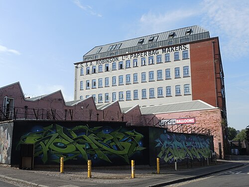 The former Robinson's paper bag factory on East Street, a tall red brick block with painted lettering, and a mural along the low wall in front of it that gets repainted every few years.