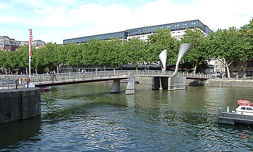Pero's footbridge, its two tall steel counterweight horns tilted up, crossing St Augustine's Reach under mature trees.