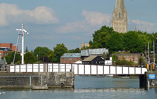 The white painted Prince Street swing bridge across the harbour, with St Mary Redcliffe's spire rising behind it.