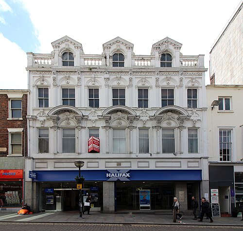 30 Bold Street, white stucco with carved swags and three dormers behind a balustrade, a bank fascia across the ground floor.