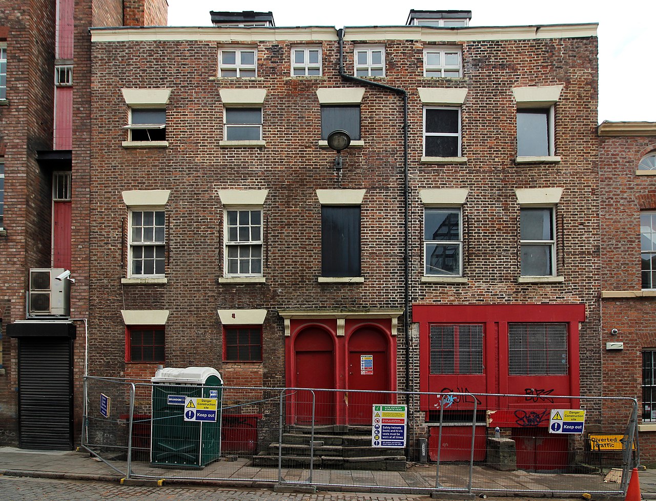 3 and 5 York Street, brick with sash windows and a pair of arched red doors up stone steps, site fencing across the front.