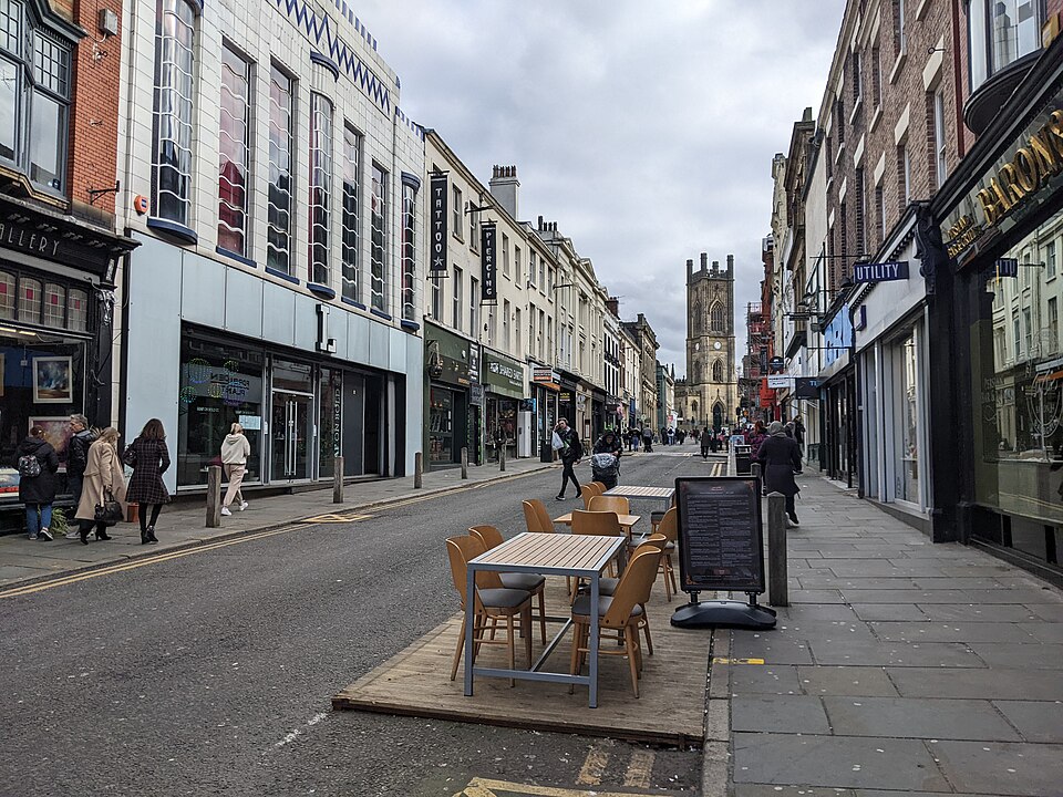 Bold Street looking up toward St Luke's, shop fronts on both sides and the church tower at the top of the street.