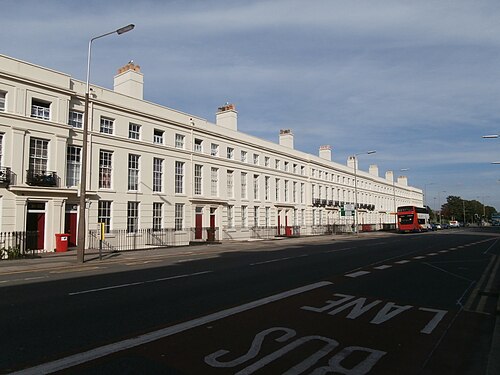 A long grand terrace of three storey cream stuccoed houses with pedimented doorcases, fronting Upper Parliament Street.