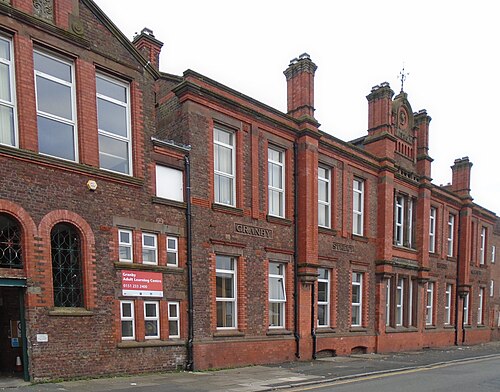 A red brick and terracotta Victorian school building on Granby Street, arched windows and carved stone lettering along the parapet.