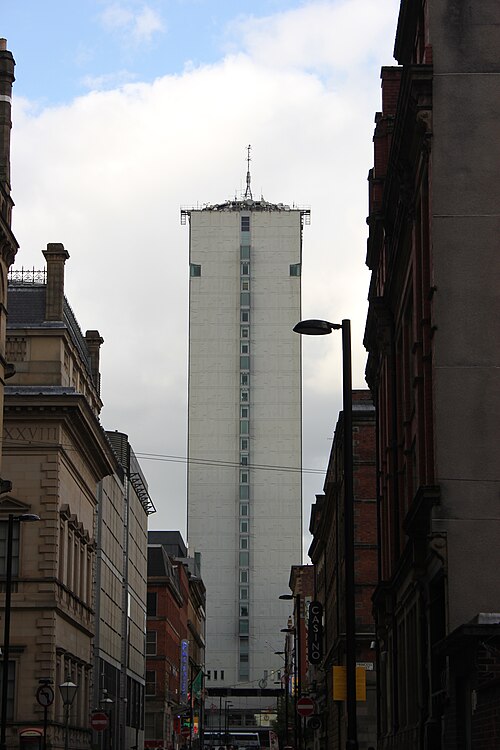 A narrow backstreet off George Street, brick warehouse walls close on both sides with City Tower rising beyond the rooftops.