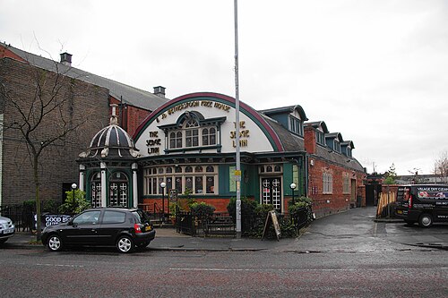 The Sedge Lynn on Manchester Road, a former Temperance Billiard Hall with a green and cream domed corner turret, arched windows and terracotta detailing, now a Wetherspoon pub.