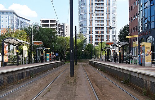 The Anchorage tram platform running dead straight between glass and brick office blocks and high rise apartments.