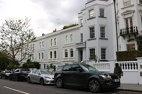 A white stucco terrace with arched windows on Kensington Park Road.