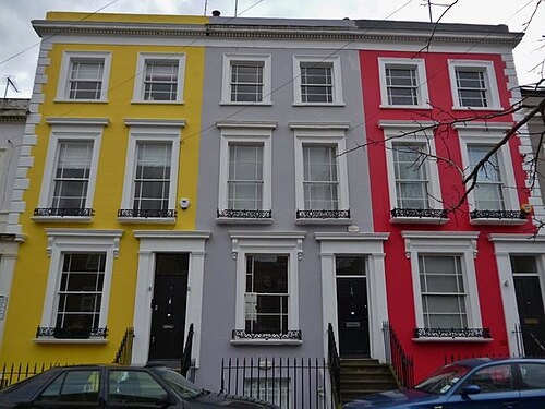 A yellow, a grey and a red terrace side by side on Denbigh Terrace.