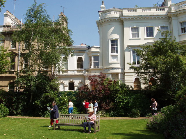 Stanley Crescent's communal garden with the stucco crescent behind the trees.