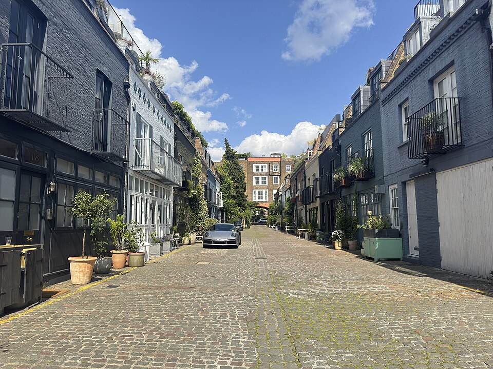 The cobbled mews between painted houses in blues and lavender.