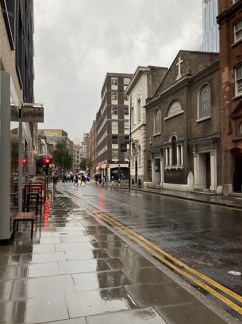 Alie Street in the rain, with St George's German Lutheran Church of 1762 on the right and newer offices standing behind it.