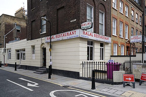 A corner building on St Mark Street painted cream and black, with hand lettered Halal Restaurant signs across three sides of it.