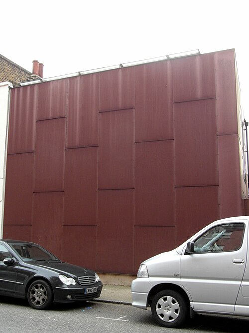 The street wall of Elektra House on Ashfield Street, dark red panels with no windows in them at all.