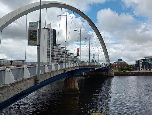 The Clyde Arc from its own deck, with the steel arch overhead and a red brick rotunda on the far bank.