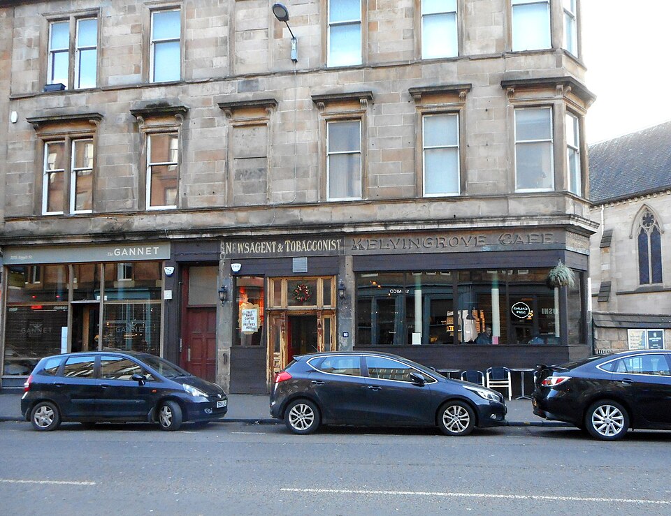 The ground floor of 1155 to 1163 Argyle Street from across the road. The Gannet's dark front is on the left, and Newsagent and Tobacconist is still cut into the stone fascia beside the Kelvingrove Cafe.