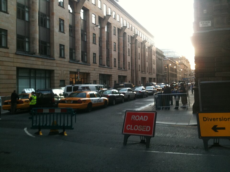 Cochrane Street closed to traffic in August 2011, with American yellow taxis parked along the near side and a Road Closed sign across the junction.