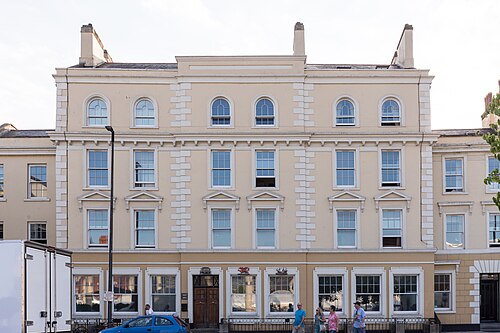 The Ocean Building's pale stucco classical facade, arched upper windows and stone quoins on a corner block.