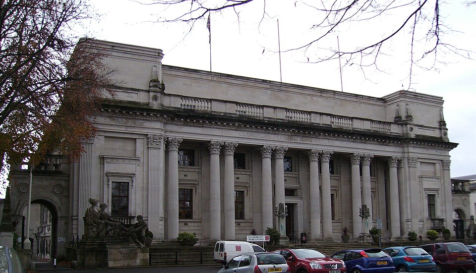 The Glamorgan Building's columned front on King Edward VII Avenue, GLAMORGAN COUNTY COUNCIL carved into the entablature above the columns and a small sculpted group at the base of one corner.
