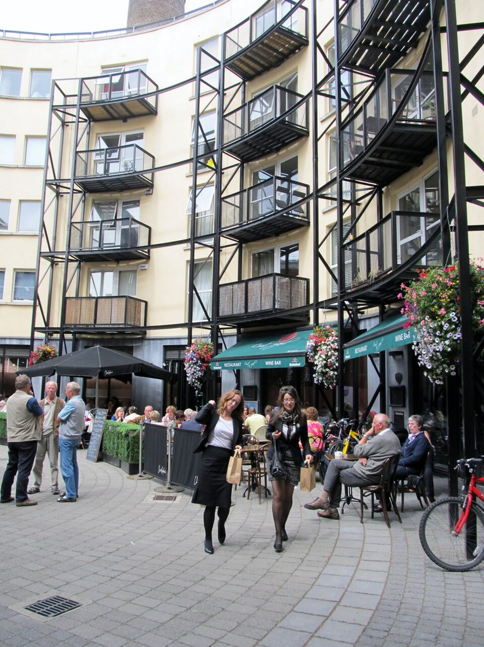 Modern apartment blocks with black steel balconies and outdoor restaurant seating built into the Old Jameson Distillery site.