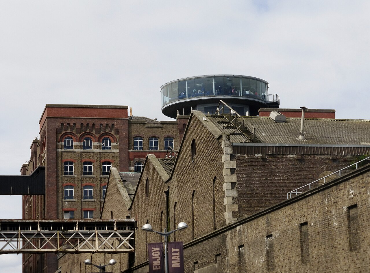 The Guinness Storehouse's brick sheds and gabled roofs, overhead pipe bridges and its circular glass observation tower.