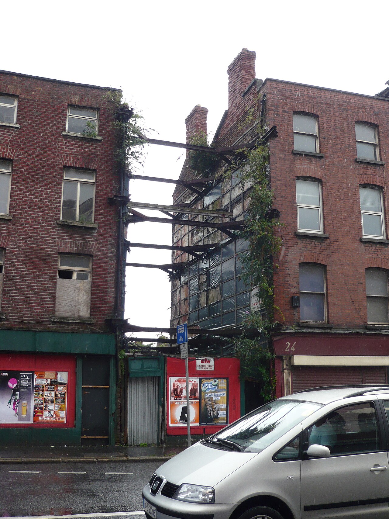 A derelict brick building on Thomas Street, braced with steel beams across a gap in the terrace.