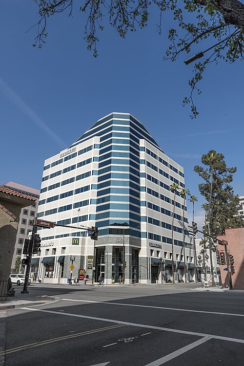 A pointed high-rise at Central Avenue and Milford Street, glass and stone with a McDonald's at street level.