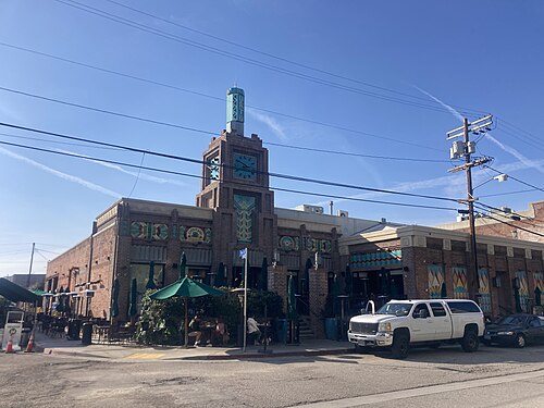A converted warehouse on Hewitt Street with an Art Deco clock tower added when it became a cafe, green umbrellas over the sidewalk tables below.