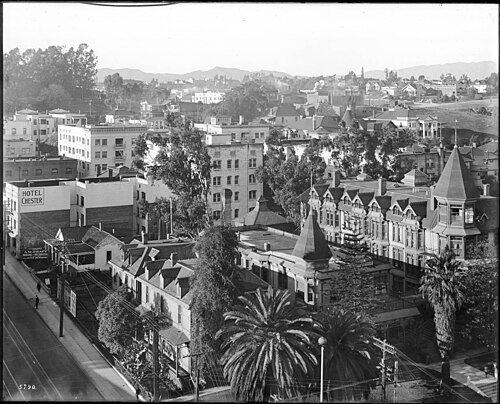 Bunker Hill around 1916, wood frame Victorian houses with a corner turret and wraparound porches, the Hotel Chester sign at the corner of the block.