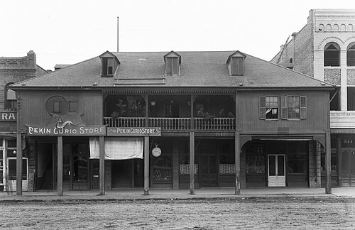 The Pekin Curio Store in the old Los Angeles Plaza area, a two story wood building with a wraparound balcony, around 1909.