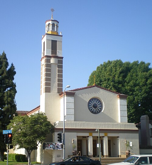 Transfiguration Catholic Church on Martin Luther King Jr. Boulevard, a tall bell tower over the sanctuary's tile roof.