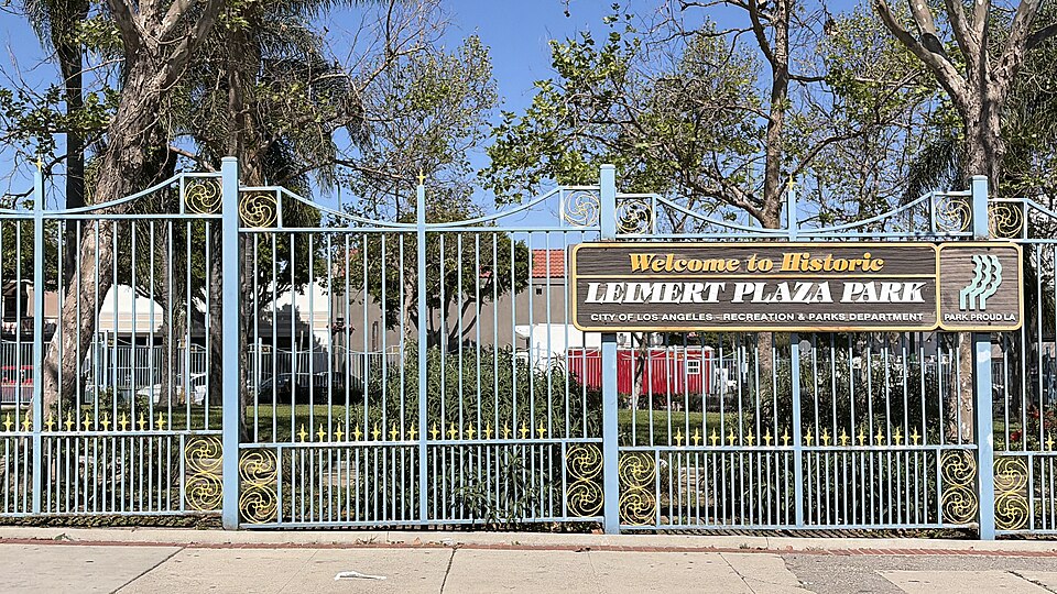 A sign on the perimeter fence of Leimert Plaza Park reading Welcome to Historic Leimert Plaza Park, City of Los Angeles Recreation and Parks Department.