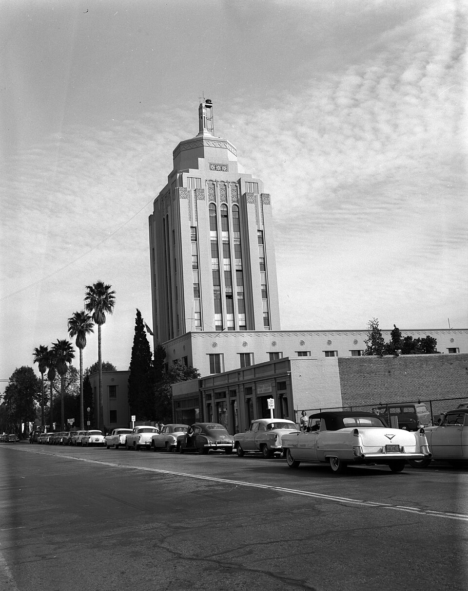 A 1956 photograph of Van Nuys City Hall from street level, cars from the period parked along the curb in front of the tower.