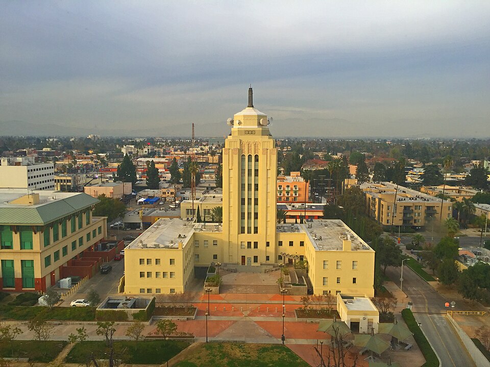 An aerial view of Van Nuys City Hall's Art Deco tower and plaza, with the surrounding blocks of Van Nuys and the San Fernando Valley behind it.