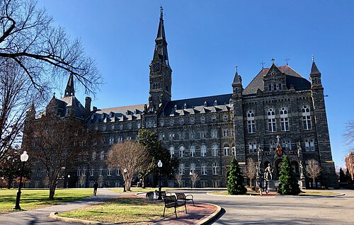 Healy Hall's Romanesque facade and clock spire from the campus lawn.