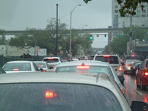 Traffic backed up on SW 7th Street toward Interstate 95, with the elevated Metromover track running above the road.