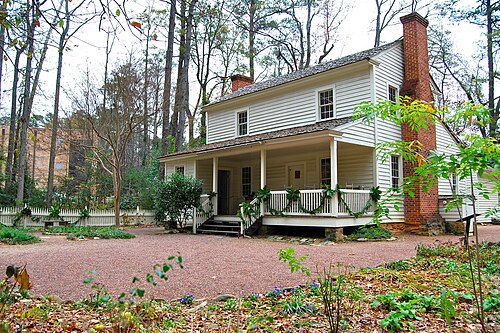 The Tullie Smith House, an 1840s farmhouse on the Atlanta History Center grounds, decorated for the holidays under bare trees.