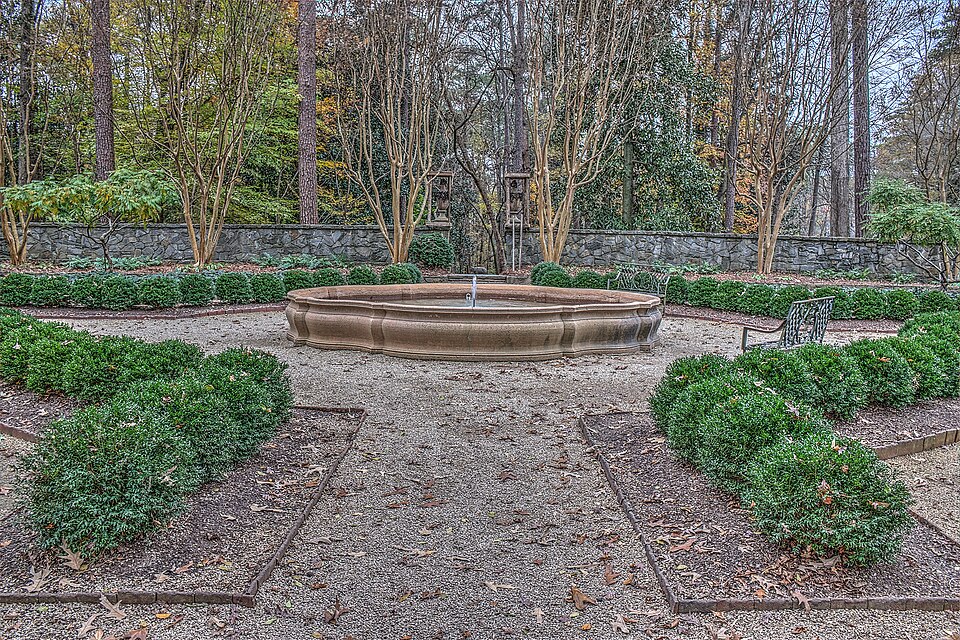 The boxwood garden behind Swan House, a round stone fountain at the center of the gravel paths.